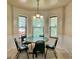 Bright breakfast nook features a round table, chandelier, and three windows overlooking the backyard at 5783 Poppy Tree Ln, Tucker, GA 30084