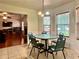 Bright breakfast nook features a round table, chandelier, and three windows overlooking the backyard at 5783 Poppy Tree Ln, Tucker, GA 30084