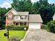 Charming two-story home with brick facade, well-maintained lawn, and an attached two-car garage at 5783 Poppy Tree Ln, Tucker, GA 30084