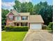 Beautiful two-story home with brick and siding, complemented by mature trees and a well-manicured lawn at 5783 Poppy Tree Ln, Tucker, GA 30084