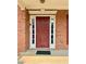 Classic red front door with sidelights, framed by brick and white trim for a welcoming entrance at 5783 Poppy Tree Ln, Tucker, GA 30084