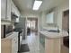 Bright kitchen featuring white cabinets and stainless steel appliances overlooking a cozy living area at 5783 Poppy Tree Ln, Tucker, GA 30084