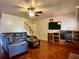 Living room with hardwood floors, a ceiling fan, a stairway, and a TV entertainment center at 5783 Poppy Tree Ln, Tucker, GA 30084