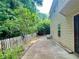 Side yard featuring a concrete patio with green foliage and fencing at 5783 Poppy Tree Ln, Tucker, GA 30084