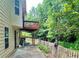 Rear patio and side yard featuring green foliage, fencing and deck at 5783 Poppy Tree Ln, Tucker, GA 30084