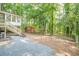 Backyard features gravel area, stairs to a deck and lush greenery at 2825 Shea Sw Way, Marietta, GA 30060