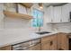 Kitchen sink under window with stainless steel dishwasher and wooden floating shelves at 2825 Shea Sw Way, Marietta, GA 30060