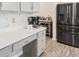 Kitchen area boasts white countertops, stainless steel appliances, updated cabinets and gray vinyl flooring at 340 Louise Ln, Canton, GA 30114