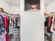 A walk-in closet with clothing hung on either side, and decor on the wall at 340 Louise Ln, Canton, GA 30114