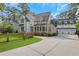 Exterior elevation of a home with a manicured lawn, a spacious driveway, and a three-car garage at 4250 Summit Dr, Marietta, GA 30068