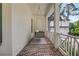 Inviting covered porch with a cozy swing, brick flooring, and white railings, perfect for relaxing outdoors at 4250 Summit Dr, Marietta, GA 30068