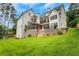 Rear exterior view of a modern home with multi-level decks, stone retaining walls, and a spacious lawn at 4250 Summit Dr, Marietta, GA 30068