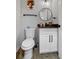 Modern powder room featuring a white vanity, black hardware, and a round mirror at 1174 Princess Sw Ave, Atlanta, GA 30310
