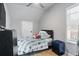 Bedroom featuring light gray walls, wood look flooring, black dresser, bed with patterned comforter and window at 1174 Princess Sw Ave, Atlanta, GA 30310