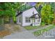 Charming cottage-style home with grey siding, a quaint front porch, and mature trees at 1174 Princess Sw Ave, Atlanta, GA 30310