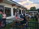 Exterior shot of a casual outdoor dining area with patrons seated at picnic tables under a gray sky at 1174 Princess Sw Ave, Atlanta, GA 30310