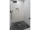 Modern walk-in shower with white tile and black hexagonal floor tiling at 1174 Princess Sw Ave, Atlanta, GA 30310