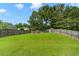 A vast backyard with a shed, fire pit area, surrounded by lush greenery and a wooden fence at 3589 Garden Manor Dr, Loganville, GA 30052