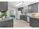 Bright kitchen with granite countertops, stainless steel appliances, grey cabinets, and hardwood floors at 3589 Garden Manor Dr, Loganville, GA 30052