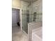 Contemporary bathroom features glass-enclosed shower with jets and tiled alcoves for storage at 704 Kenton Ct, Locust Grove, GA 30248