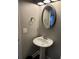 Cozy bathroom with pedestal sink, brushed nickel fixtures, and a decorative oval mirror at 704 Kenton Ct, Locust Grove, GA 30248