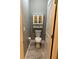Compact half-bathroom with modern toilet, storage cabinet, and tile flooring at 704 Kenton Ct, Locust Grove, GA 30248