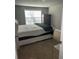 Simple bedroom with a large window, neutral carpet, and a comfortable queen size bed at 704 Kenton Ct, Locust Grove, GA 30248