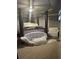 This is the main bedroom with a regal four-poster bed and sitting area bathed in soft light at 704 Kenton Ct, Locust Grove, GA 30248