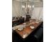 Elegant dining room featuring a long wooden table with formal settings and a stylish chandelier at 704 Kenton Ct, Locust Grove, GA 30248