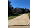 Long driveway leading to a well-maintained two-story home, enhanced by lush green surroundings at 704 Kenton Ct, Locust Grove, GA 30248