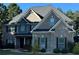 Beautiful two-story brick home featuring a well-manicured lawn and complemented by mature trees against a bright blue sky at 704 Kenton Ct, Locust Grove, GA 30248