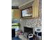 Brick fireplace with wooden doors, TV, and decorative accents in sunroom at 704 Kenton Ct, Locust Grove, GA 30248