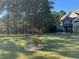 Green lawn featuring a small tree with decorative rock surround near this well-maintained property at 704 Kenton Ct, Locust Grove, GA 30248