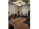 A home gym with an elliptical machine, weight rack, bench and ceiling fan at 704 Kenton Ct, Locust Grove, GA 30248