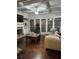 Open living room featuring a brick fireplace, hardwood floors, and large windows for natural light at 704 Kenton Ct, Locust Grove, GA 30248