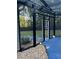 Outdoor pool area enclosed with screened walls and doorway leading to backyard at 704 Kenton Ct, Locust Grove, GA 30248