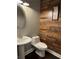 Powder room featuring stylish wood accent wall and pedestal sink at 704 Kenton Ct, Locust Grove, GA 30248
