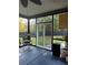 Bright sunroom with sliding doors, potted plants, and views of the backyard at 704 Kenton Ct, Locust Grove, GA 30248