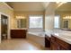 Spacious bathroom featuring double vanity, tub beneath window, and large mirrors at 203 Crescent Moon Way Way, Canton, GA 30114