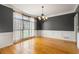 Bright dining room with hardwood floors, large windows, wainscoting, and a modern chandelier at 203 Crescent Moon Way Way, Canton, GA 30114