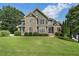 Charming two-story home with a stone and siding exterior and a beautifully manicured lawn at 203 Crescent Moon Way Way, Canton, GA 30114