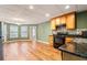 This open kitchen features wood floors, oak cabinetry, and stainless steel appliances at 203 Crescent Moon Way Way, Canton, GA 30114