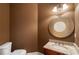 Stylish powder room featuring granite countertops, wood cabinet, bronze mirror, and decorative lighting at 203 Crescent Moon Way Way, Canton, GA 30114