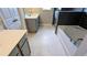 Clean bathroom with modern fixtures, a sleek vanity, white tiled floors, plus a combined tub and shower at 301 Hayden Cir, Woodstock, GA 30189