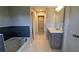 Modern bathroom with a tub, walk-in closet, double vanity, and white tiled floors for a clean and comfortable feel at 301 Hayden Cir, Woodstock, GA 30189