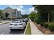Street with parked cars and townhomes, lush green space and sidewalks create a charming and walkable neighborhood at 301 Hayden Cir, Woodstock, GA 30189