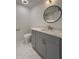 Stylish bathroom featuring a gray vanity, marble countertops, and a modern round mirror at 365 Morning Dew Cir, Roswell, GA 30075