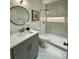 A bathroom featuring marble tile, glass shower, and modern vanity with round mirror at 365 Morning Dew Cir, Roswell, GA 30075