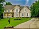 Charming two-story home with a well-manicured lawn and inviting front porch at 365 Morning Dew Cir, Roswell, GA 30075