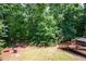 Backyard area featuring a fire pit, red Adirondack chairs, mature trees and a spa area at 3990 Wesley Chapel Rd, Marietta, GA 30062
